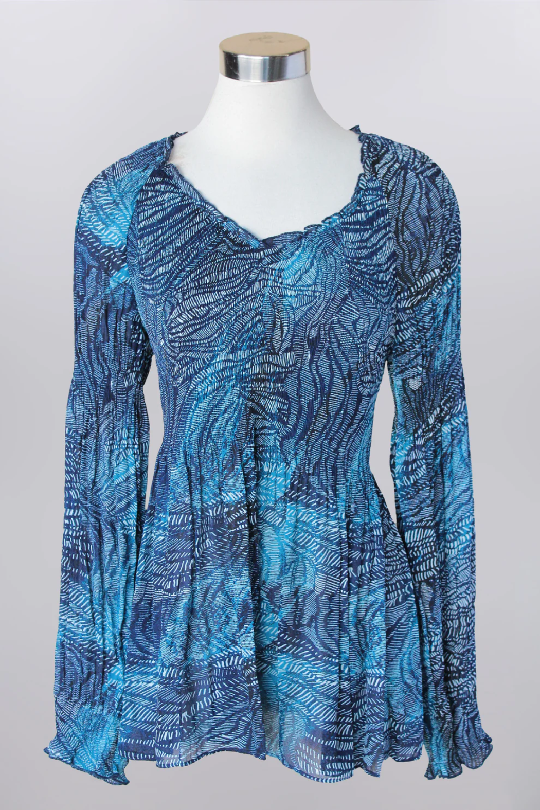 Blue patterned blouse on a mannequin against a gray background